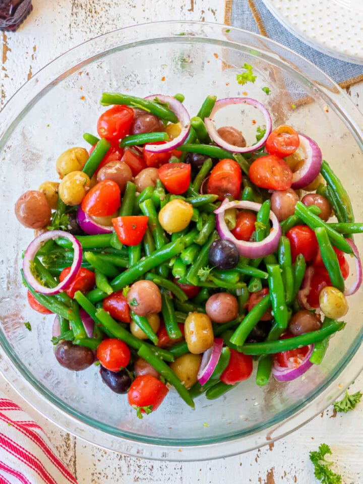 Overhead view of a bowl of green beans, tomatoes, potatoes, and red onions created for the feature image of this post.