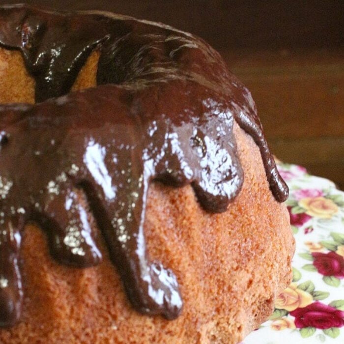 Closeup of vanilla bundt cake with a chocolate drip glaze.