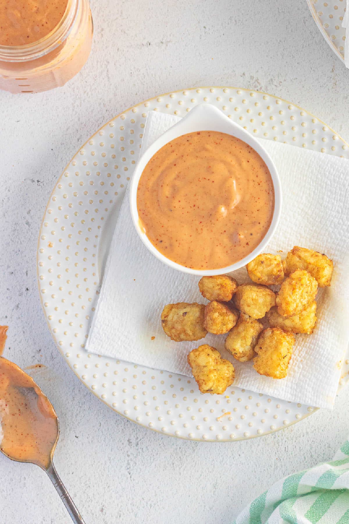 Overhead view of the sauce in a bowl with tater tots on a plate.