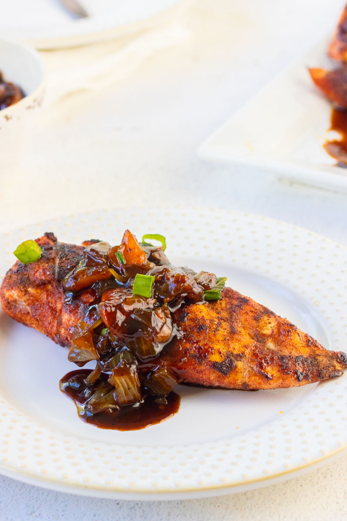 A golden brown chicken breast covered with spicy bourbon peaches.