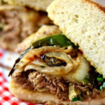 Closeup of a steak sandwich showing the layers of ingredients.