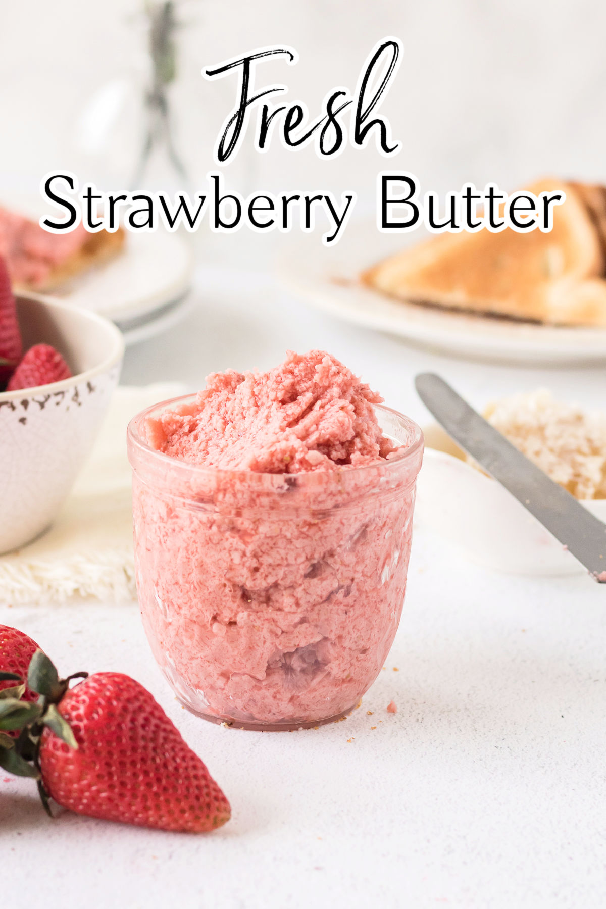 A jar of pink strawberry butter on a table. Title text overlay.