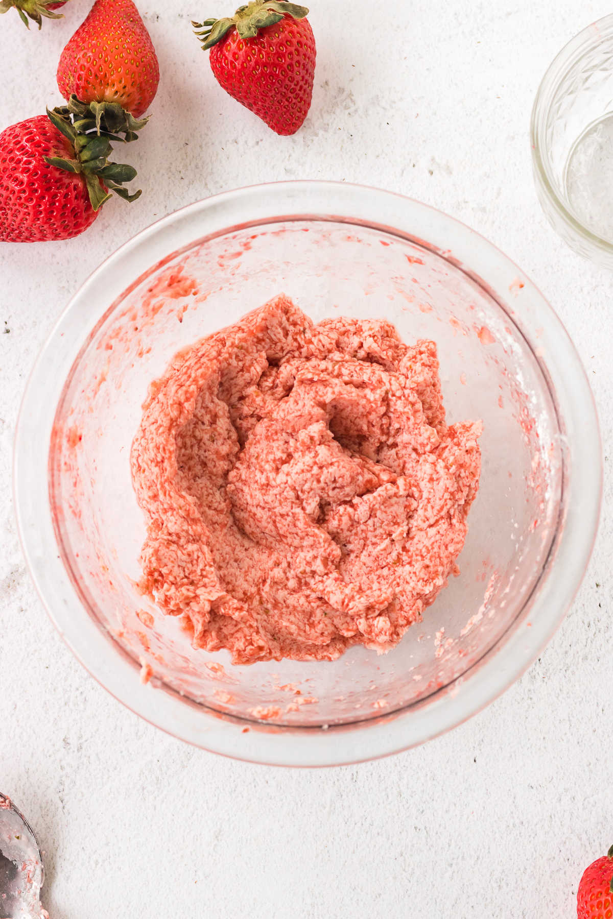 Overhead view of strawberry butter in a glass bowl.