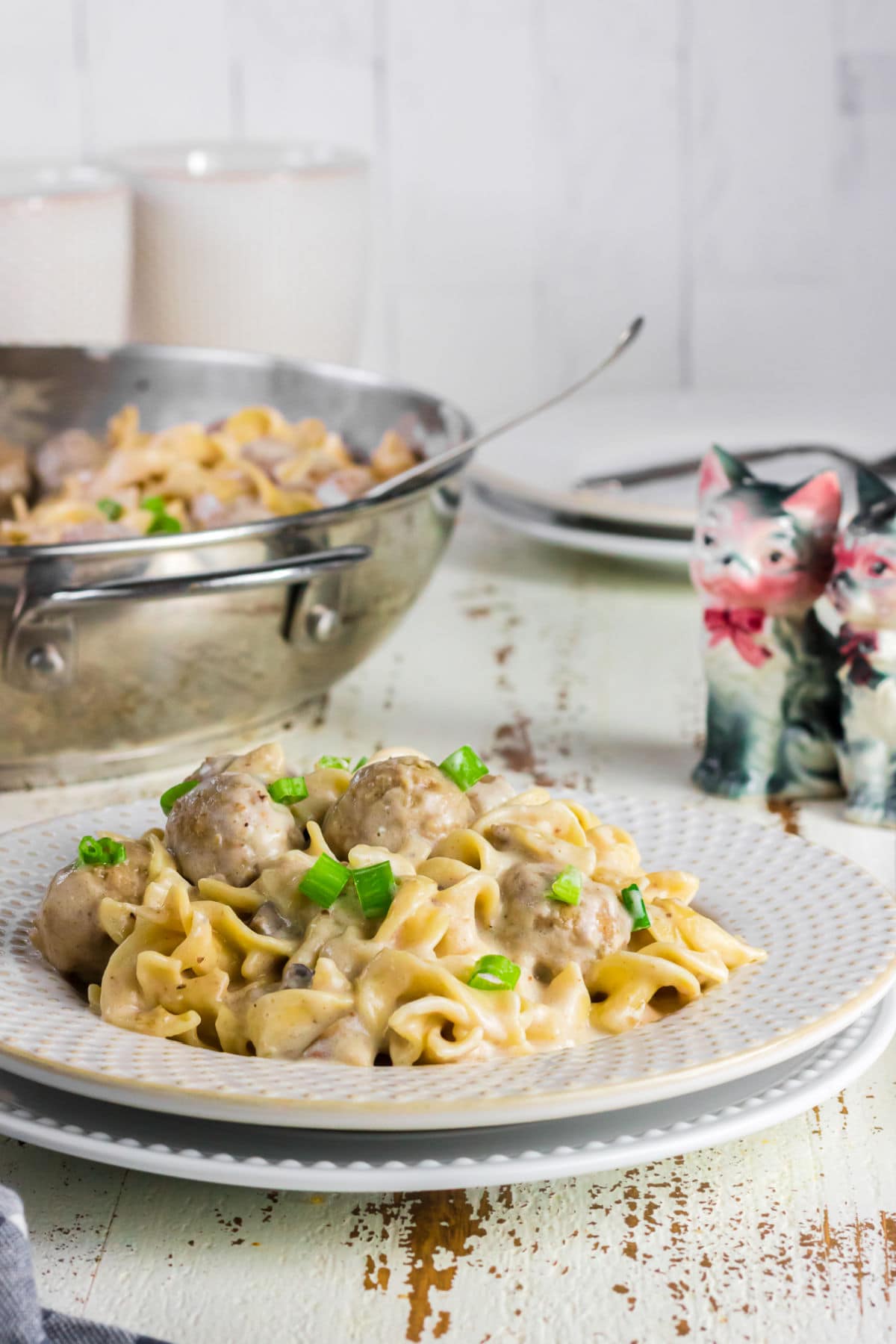 A serving of meatballs and noodles on a white plate.