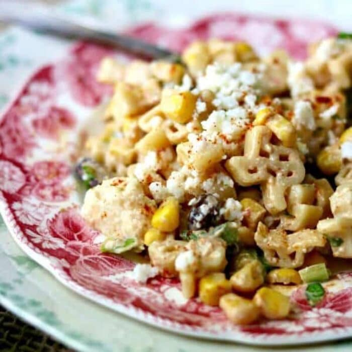 Macaroni salad made with Texas shaped pasta on a red plate.