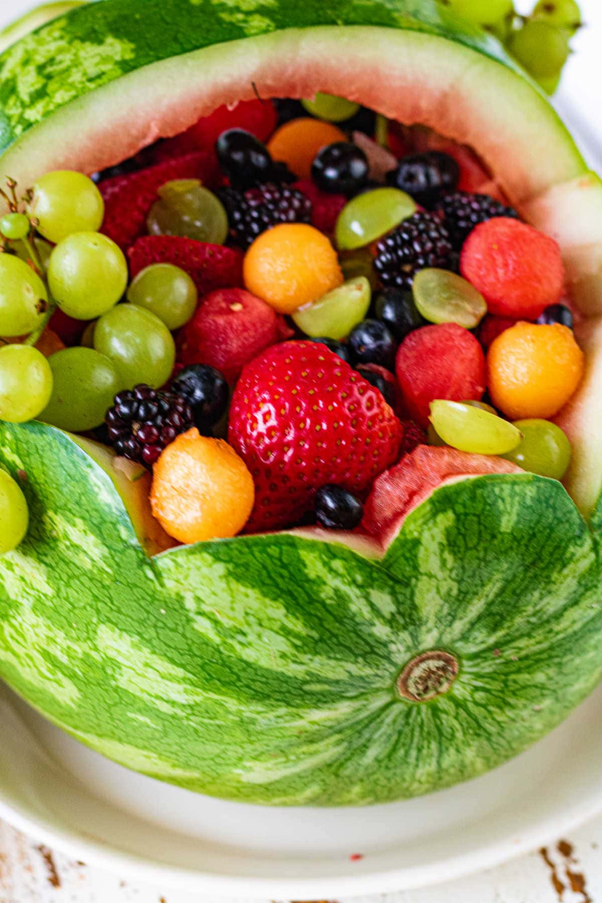 Overhead view of a watermelon basket filled with fruit.