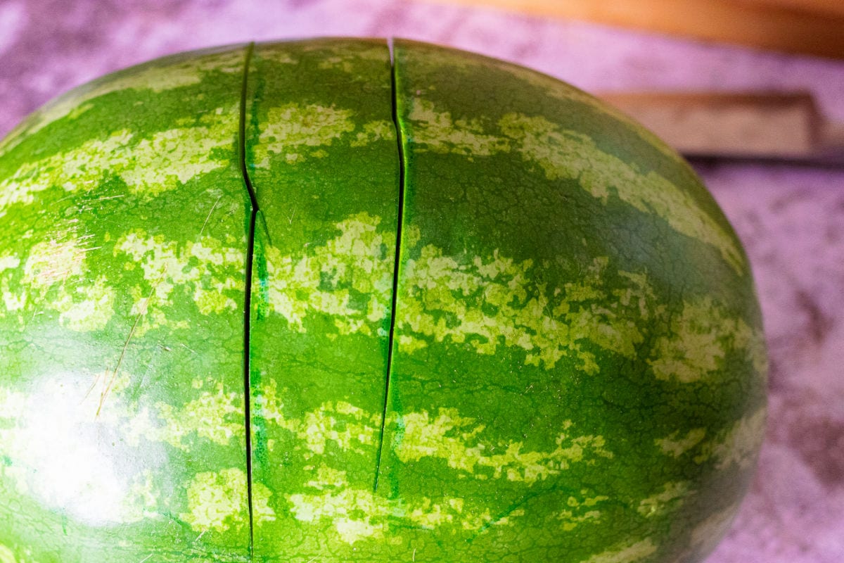 Two deep cuts on a watermelon outlining the handle.