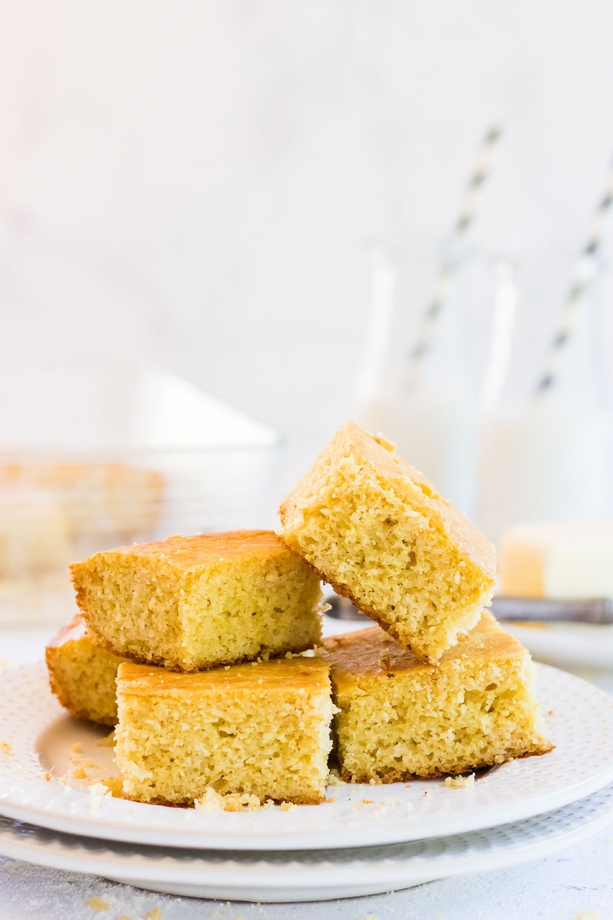 Buttermilk cornbread cut n squares and stacked on a plate.