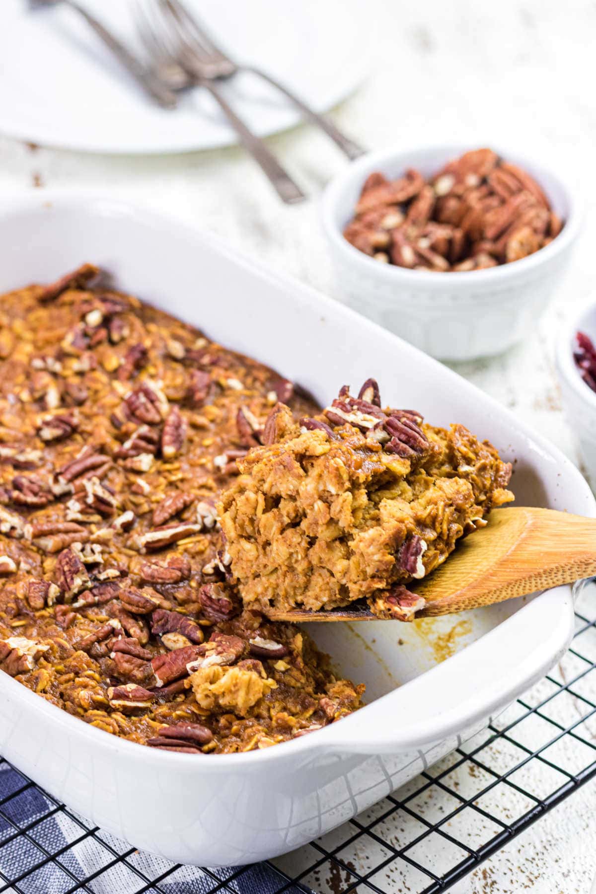 A serving of baked pumpkin oatmeal being removed from the serving dish.