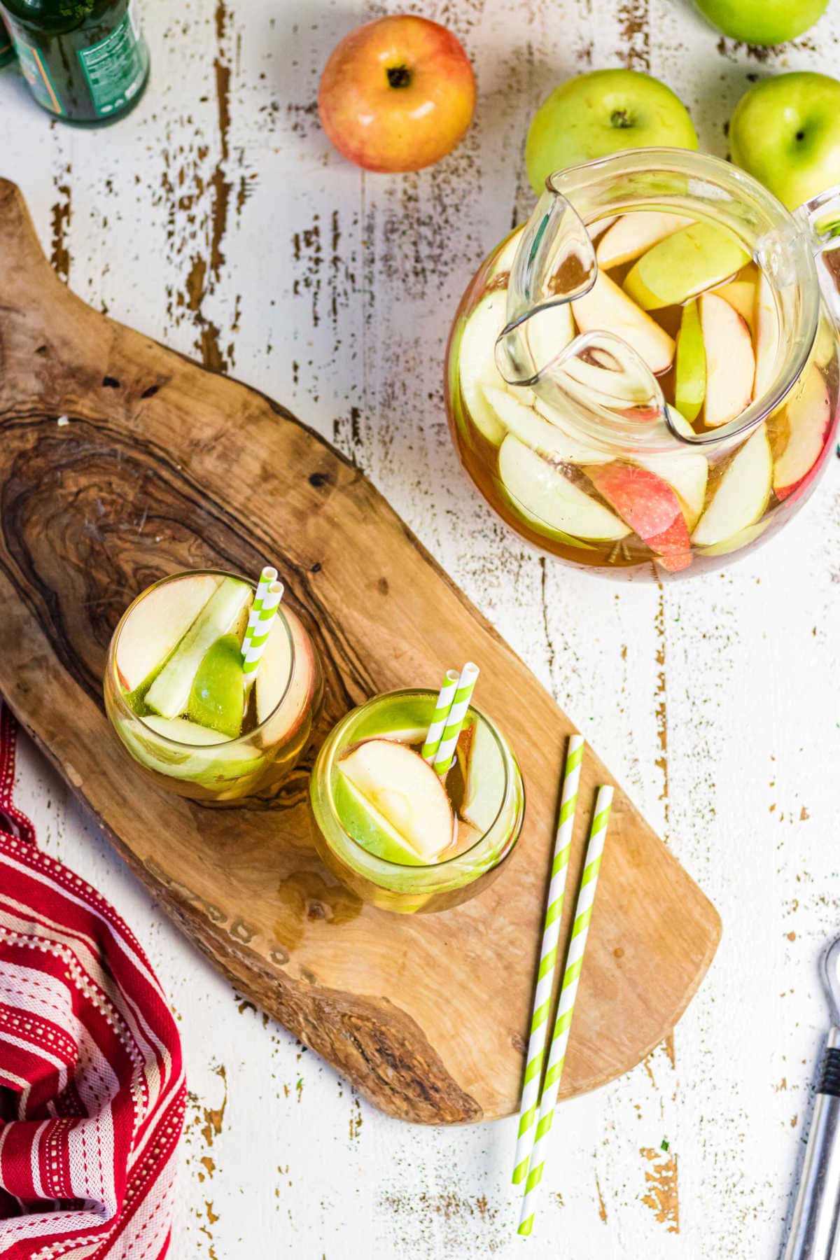 Overhead view of a pitcher of apple sangria and two glasses.