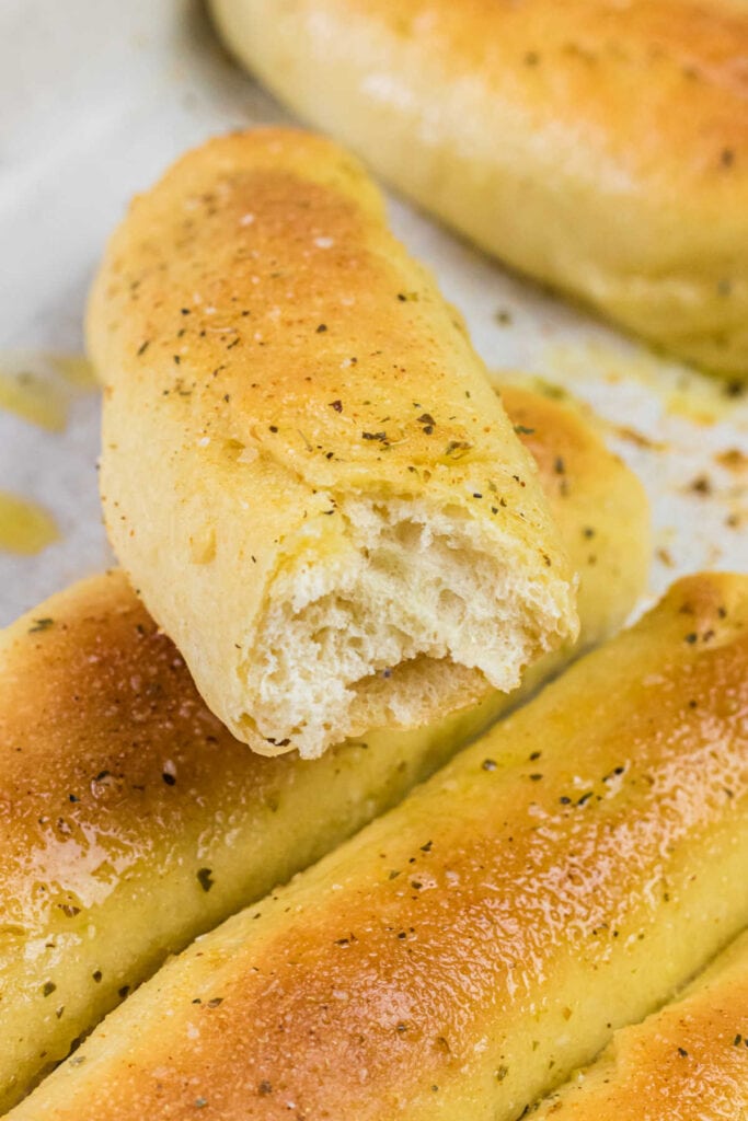 Close up of a breadstick opened to show the inside texture.