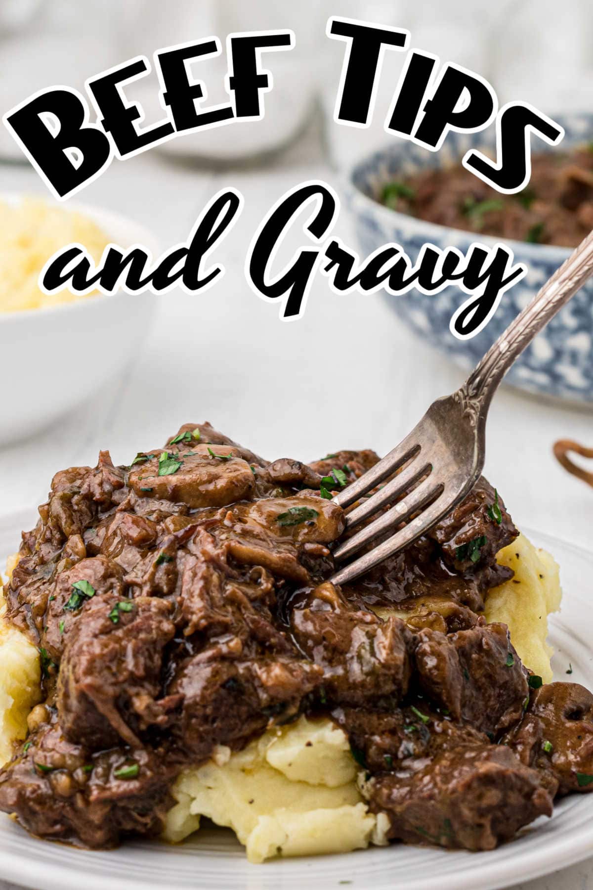 A fork in a serving of luscious beef and mashed potatoes. Title image for beef tips and gravy.