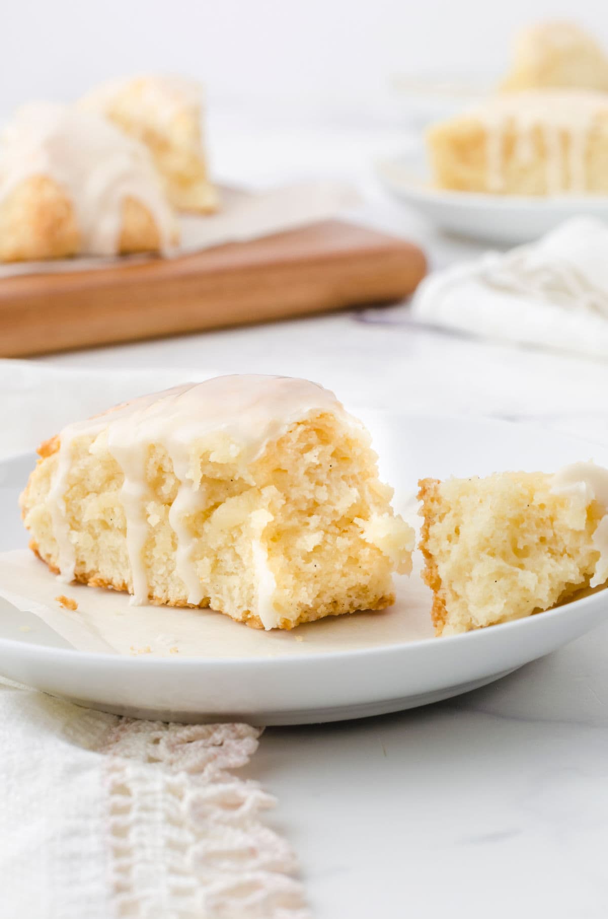 A scone on a plate with the tip broken off.