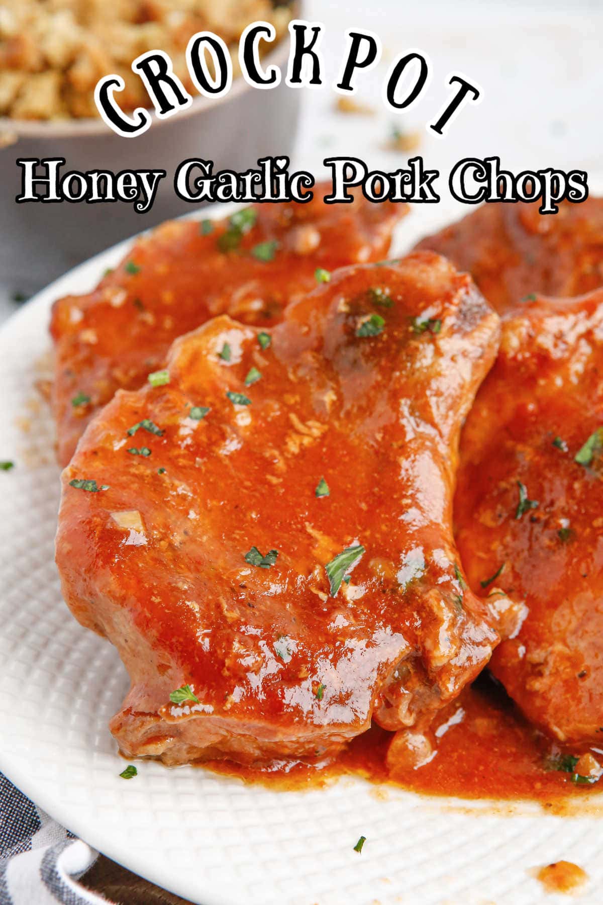 Side view of the honey garlic pork chops on a serving plate with  title text overlay.