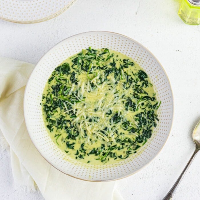 Overhead view of a plain bowl of creamed spinach.