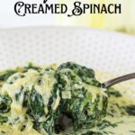 A spoonful of creamed spinach being lifted from a bowl with text overlay for Pinterest.