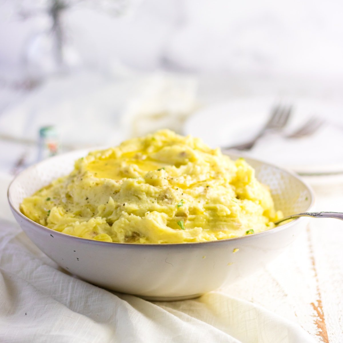 Side view of a white bowl of mashed potatoes.