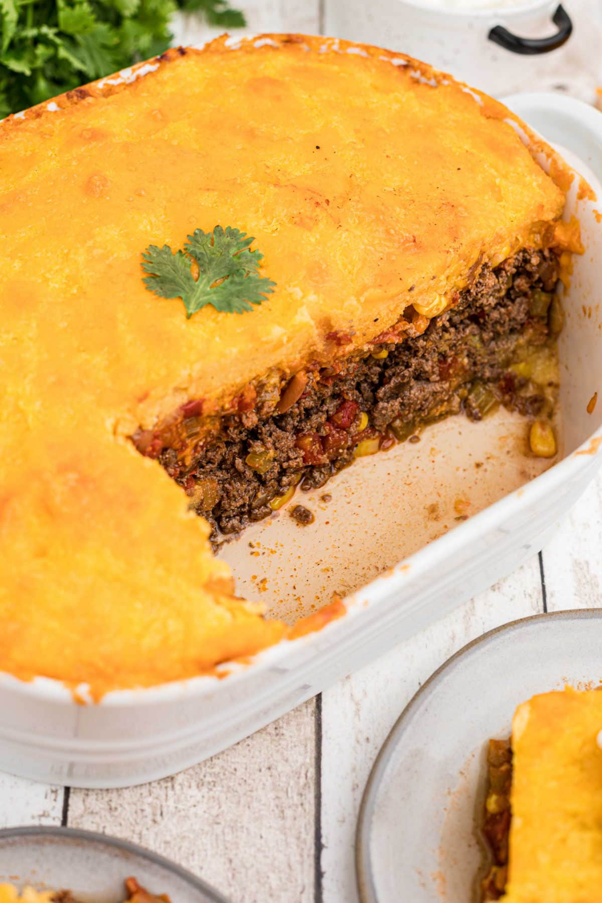 Tamale Pie with a serving removed showing the layers of ingredients.