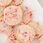 Overhead view of cherry cookies on a white plate.