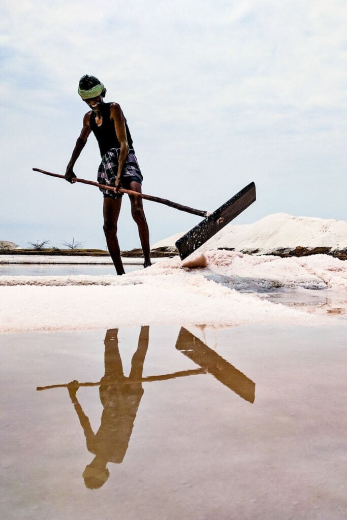 A man using a shovel to harvest salt.