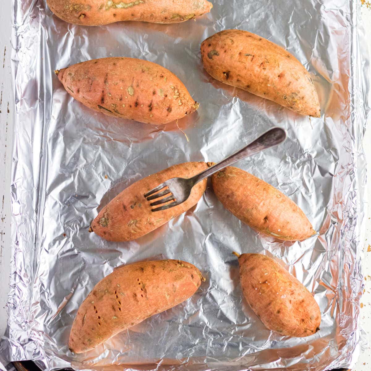 A fork stuck in a sweet potato.