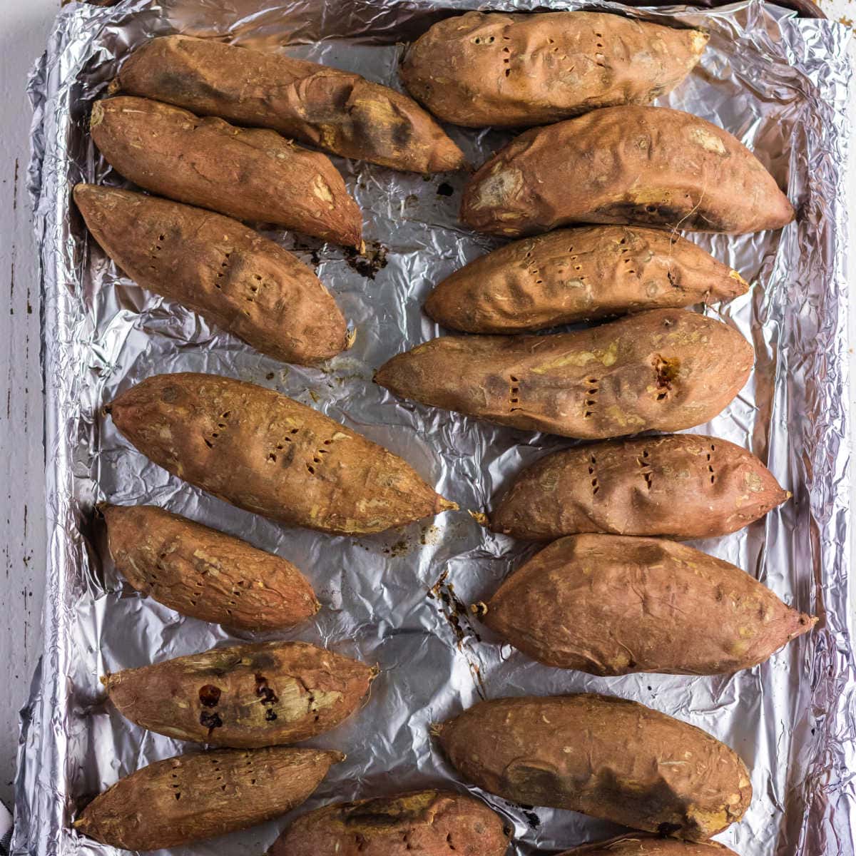 Baked sweet potatoes on a baking sheet.