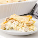 A closeup of a serving of lasagna on a white plate.