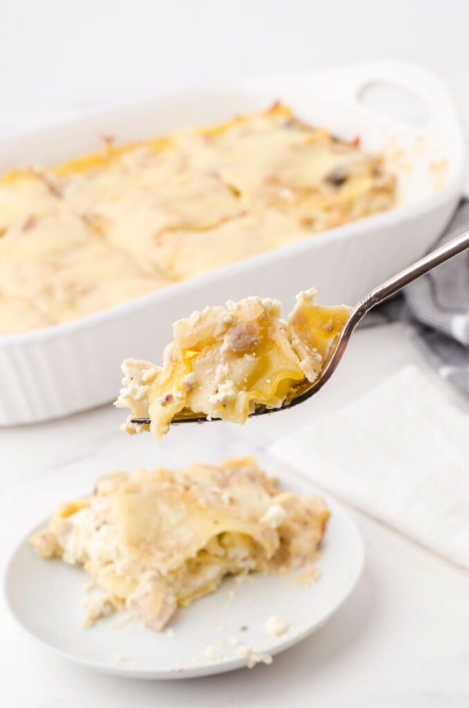 A forkful of the lasagna being lifted up from a plate.