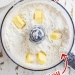 Overhead view of pie crust being made in a food processor with text overlay for Pinterest.