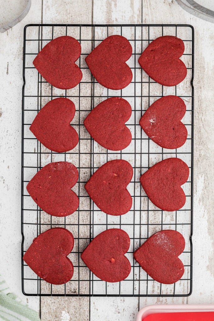 Baked Valentine's Day heart cookies cooling on a rack.