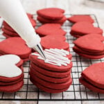 Stacks of cookies being decorated.