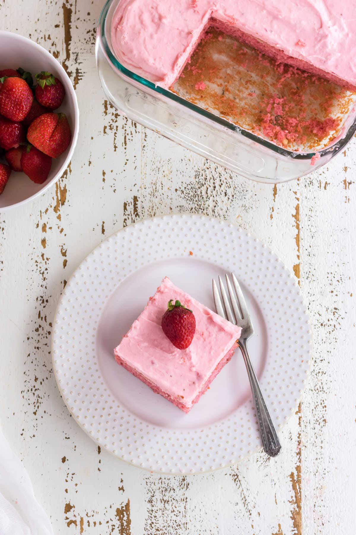 Overhead view of a square of cake on a white plate.