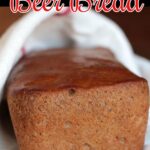 Loaf of beer bread cooling on a table. Text overlay for Pinterest.