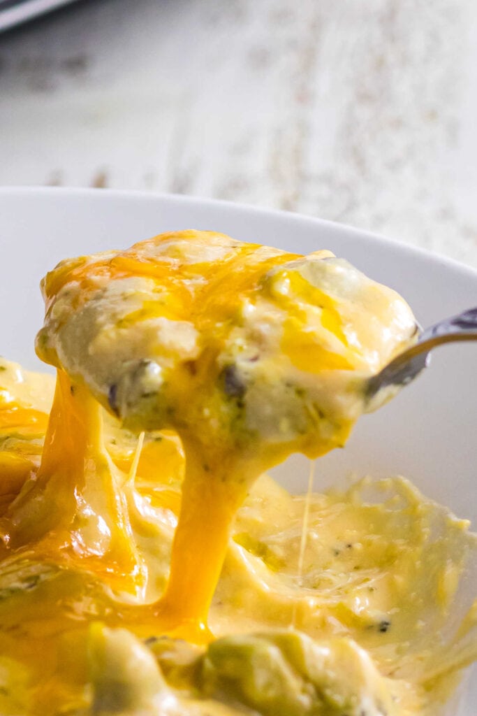 Closeup of a spoonful of the soup covered in melted cheese.