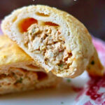 Closeup of chicken crescent rolls cut to show the interior.