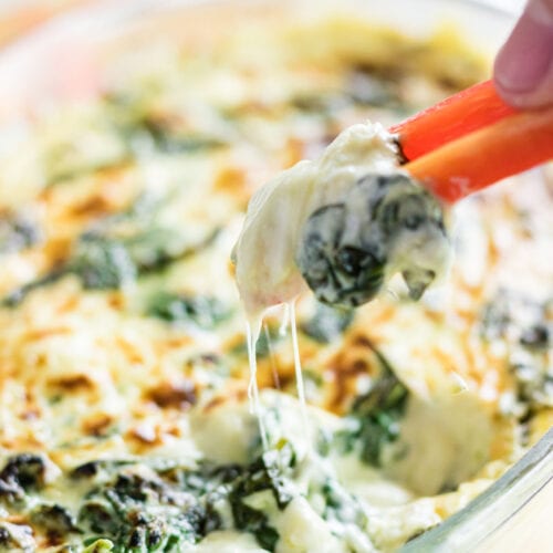 Closeup of a pepper being dipped in spinach dip.