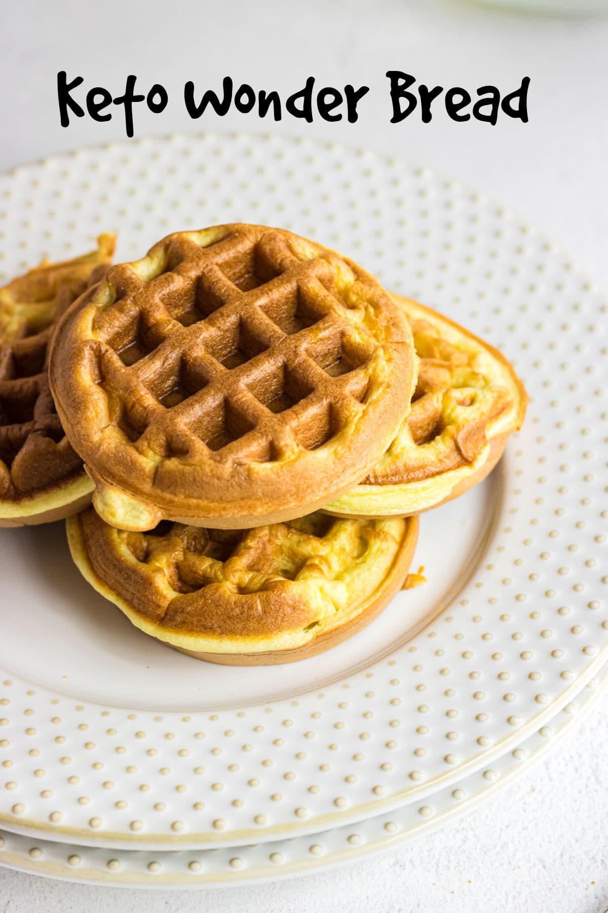 Closeup of keto wonder bread chaffles on a plate with a title text overlay.