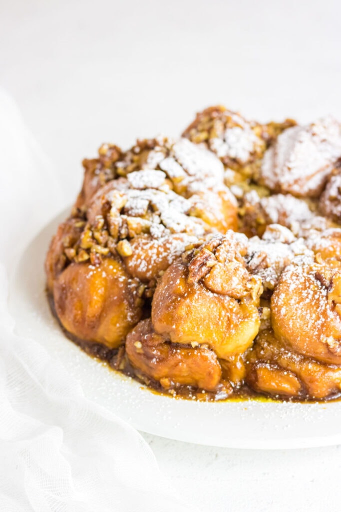 Side view of the cream cheese stuffed monkey bread with powdered sugar.