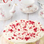 A whole red velvet cheesecake on a white plate. Title text overlay for Pinterest.