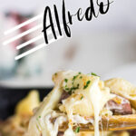Closeup of a spoonful of sausage Alfredo with gooey cheese coming off the spoon. Text overlay for Pinterest.