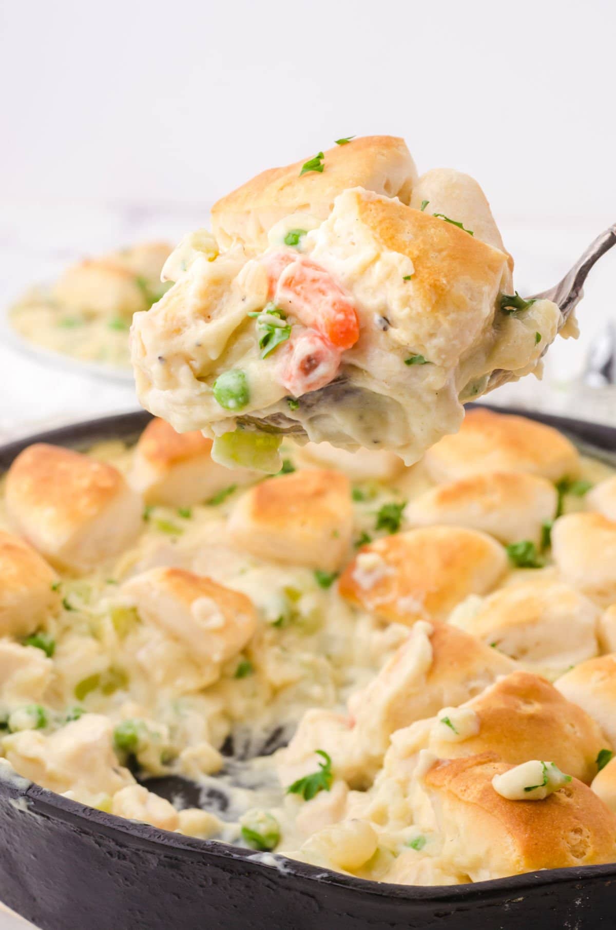 A scoop of chicken pot pie being lifted out of the pan.