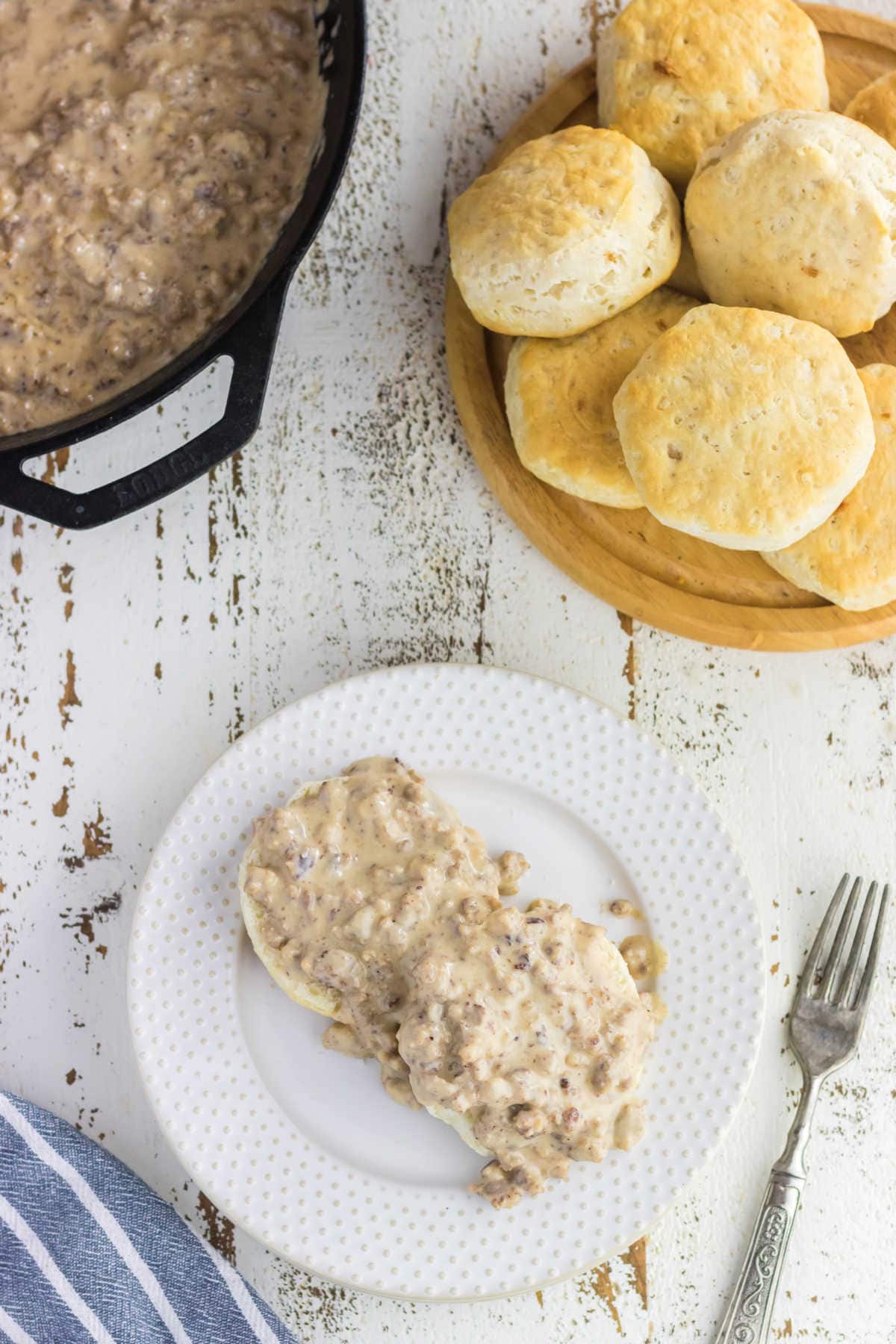 Overhead view of biscuits and gravy on a white plate.