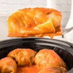 Closeup of a cabbage roll on a serving spoon.