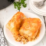 Cut cabbage rolls on a plate showing the filling.