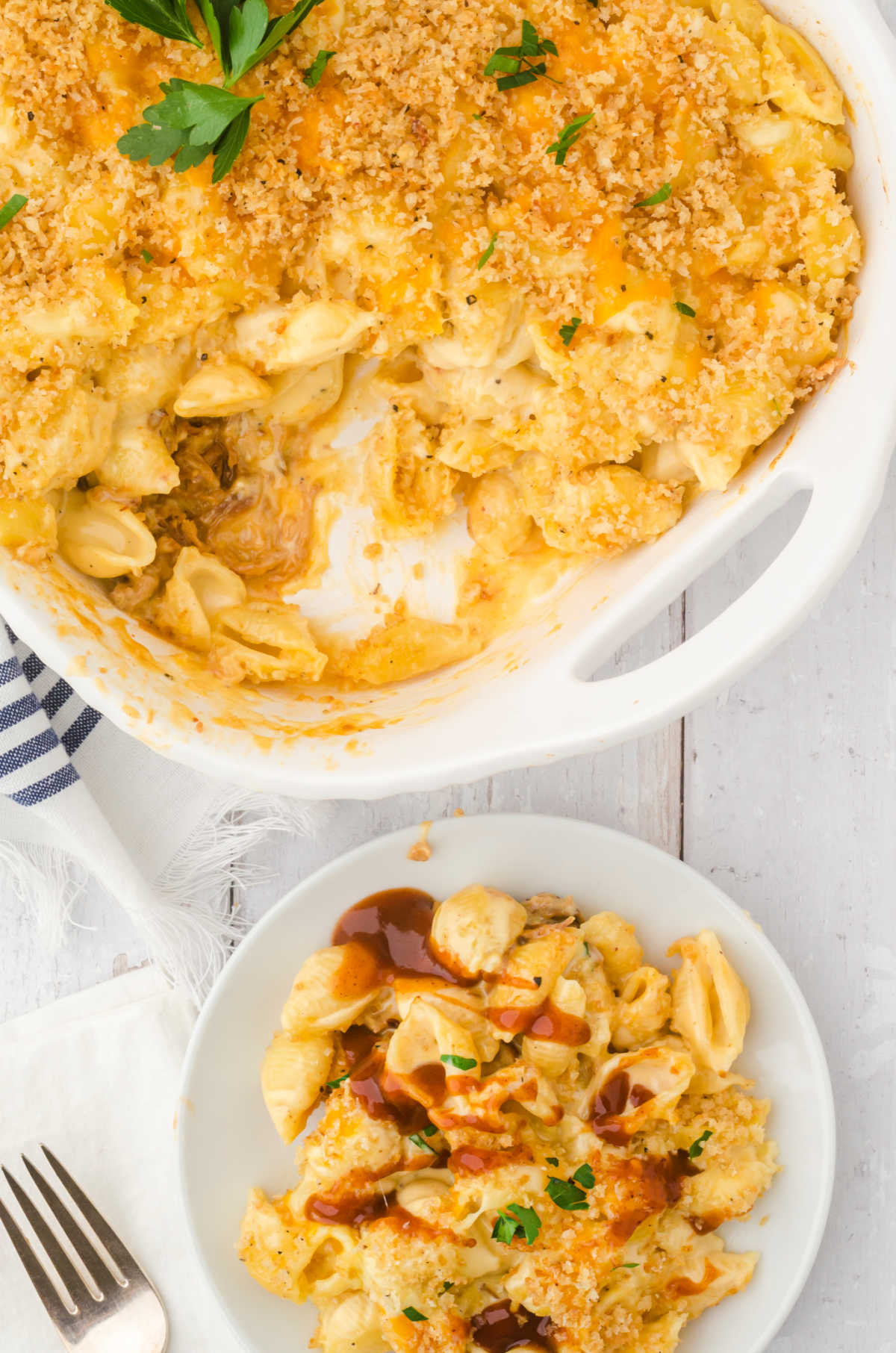 An overhead view of a plate of mac and cheese next to a casserole.