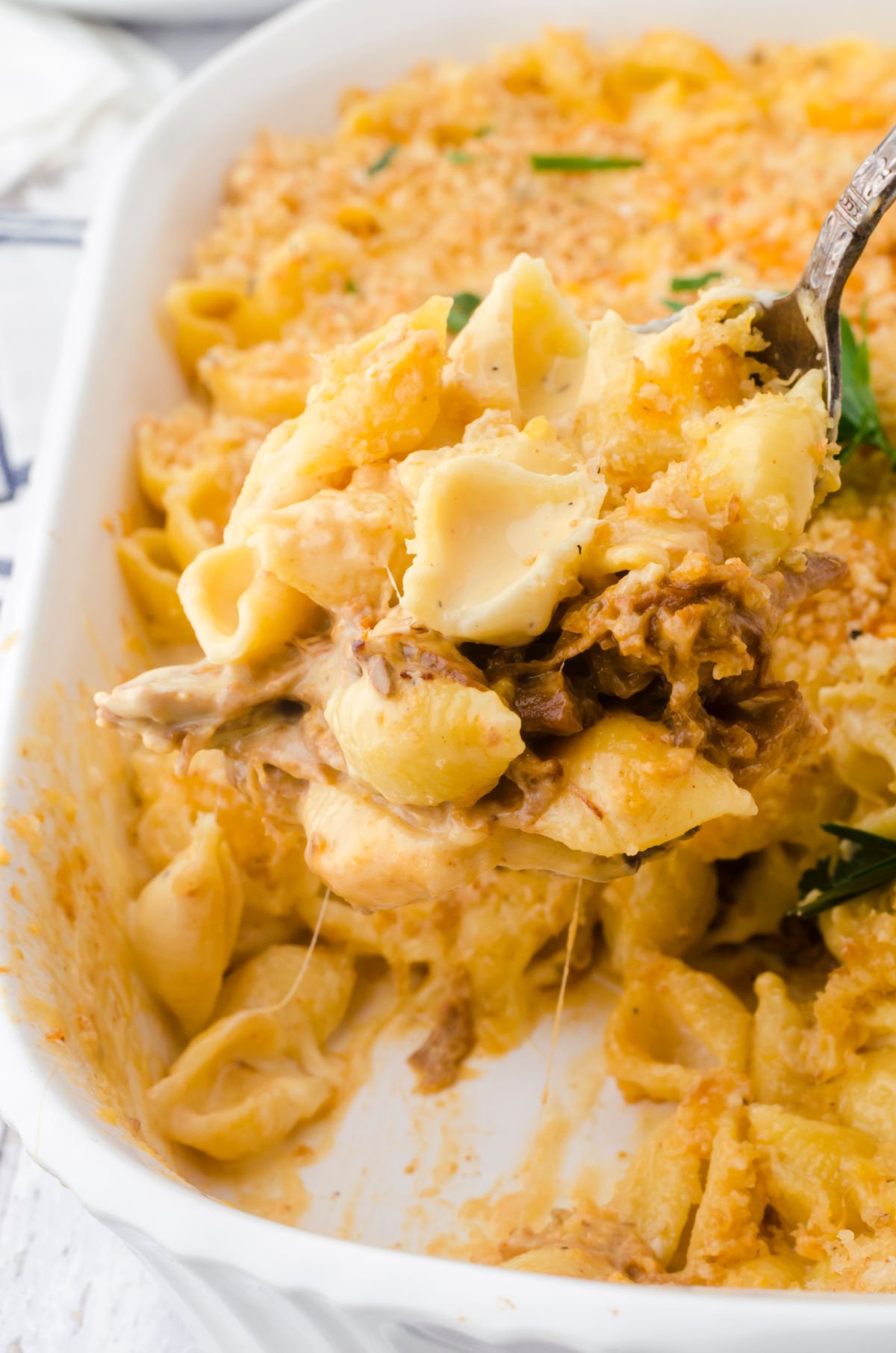 A scoop of mac and cheese being removed from the casserole dish.