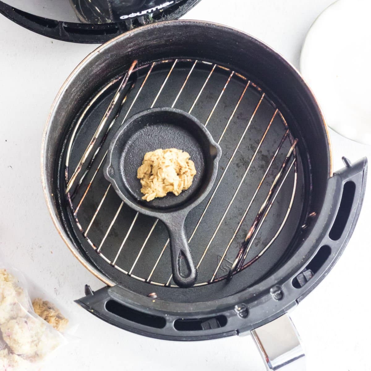 The cookie dough in a pan on the rack of the air fryer.