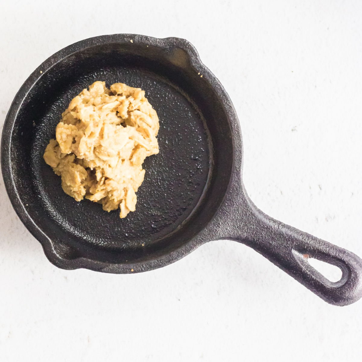 Frozen cookie dough on a baking surface for the air fryer.