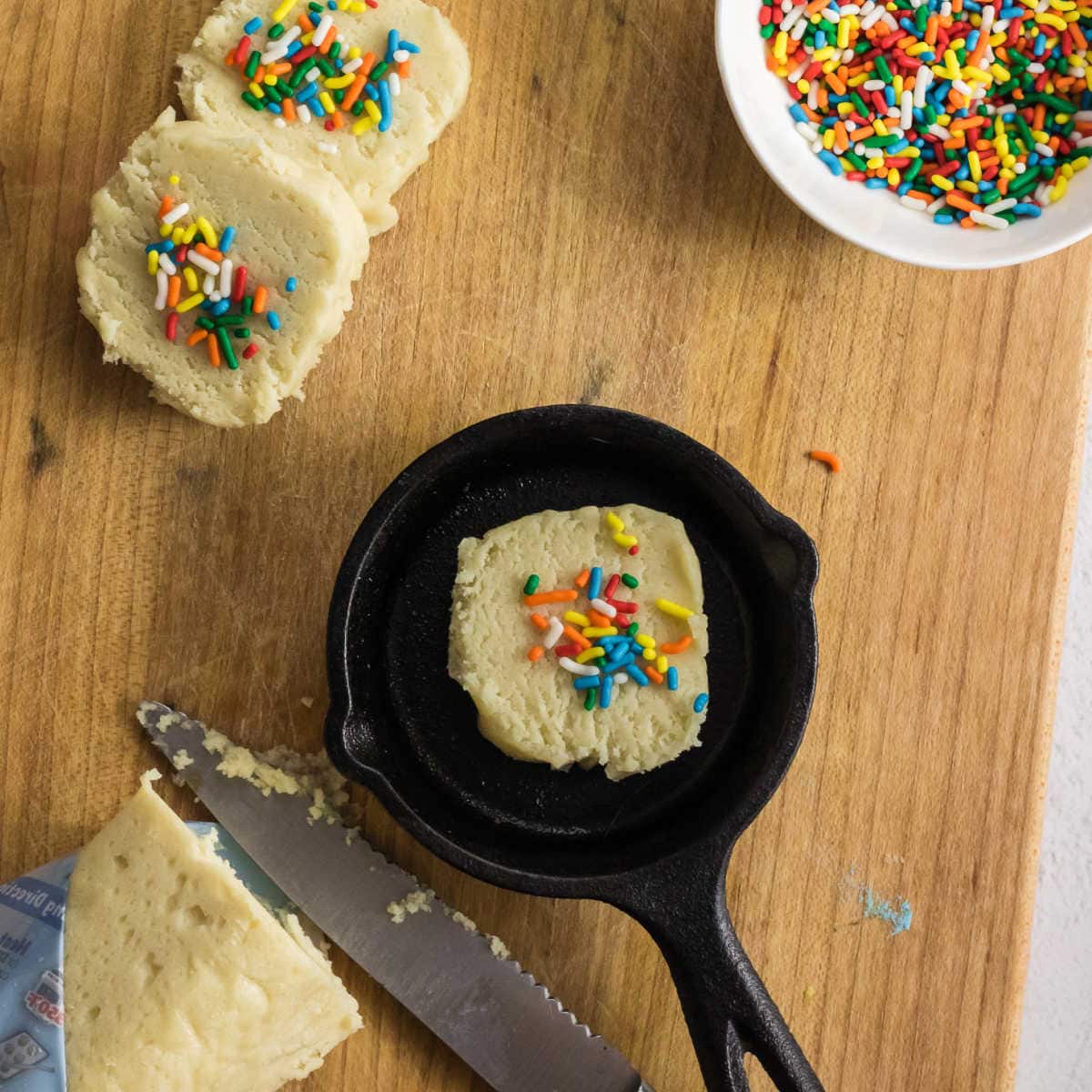 Cookie dough with sprinkles on it in a pan.