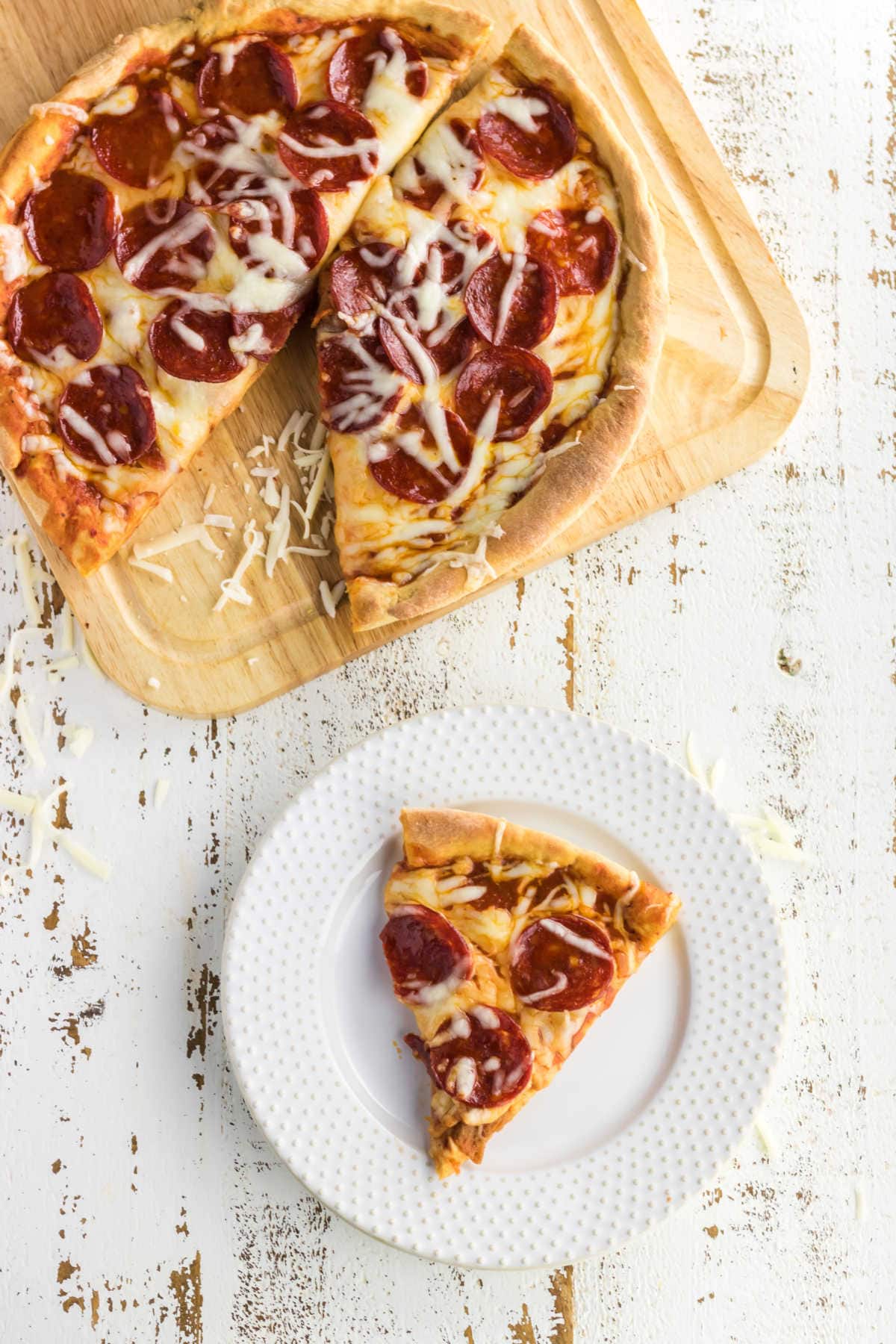 Overhead view of pizza with a slice on a plate.